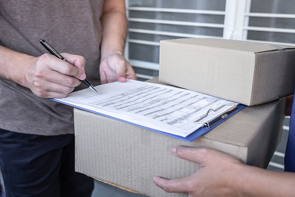 Young Delivery man deliver box parcel package and sending to customer in front of the house, Man customer signing in clipboard form to receive package, shipping delivery concept