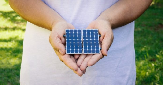 holding-photovoltaic-panel-in-natural-background-picture-id925712896